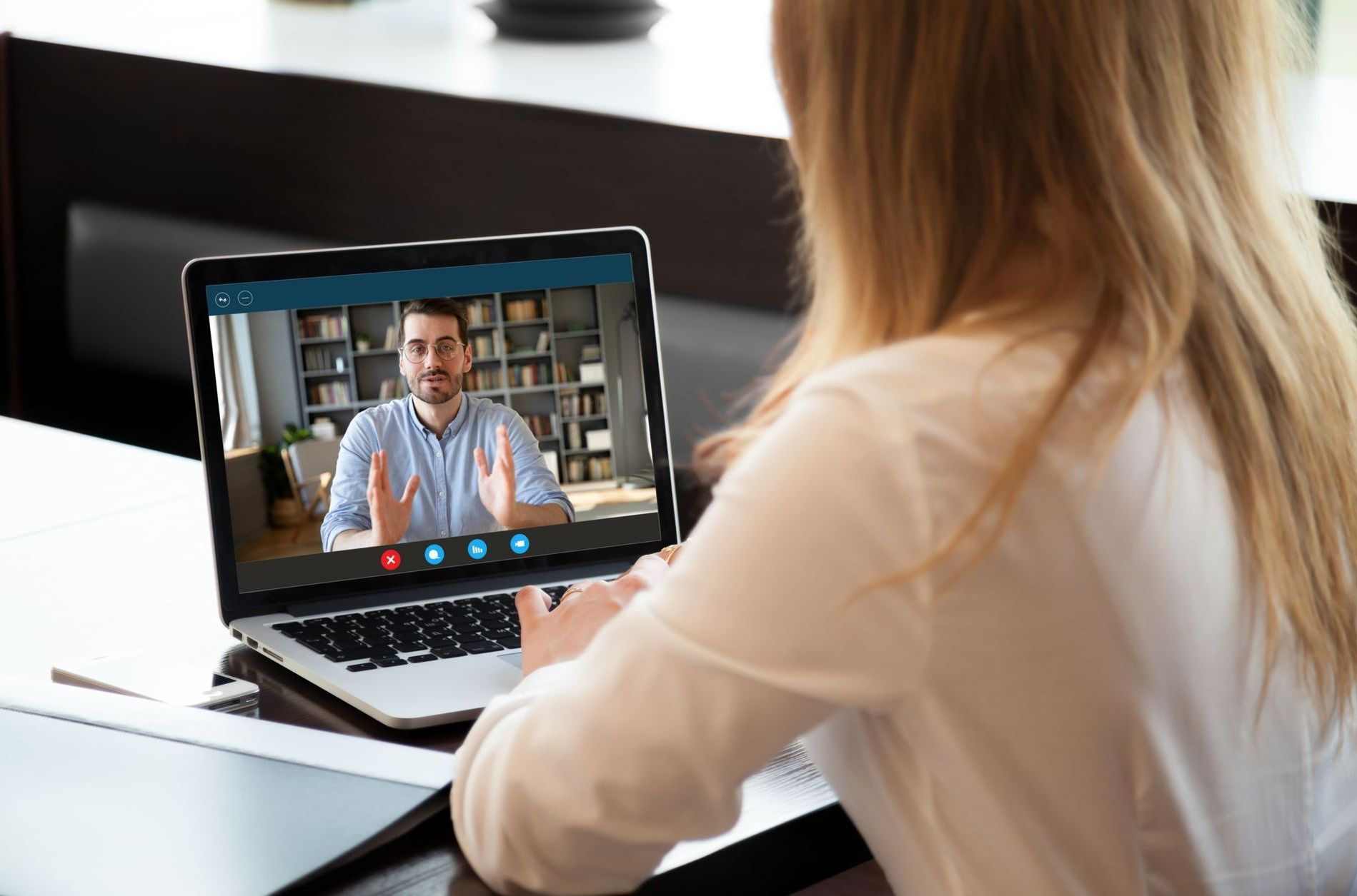 A woman is having a video call with a man on a laptop.