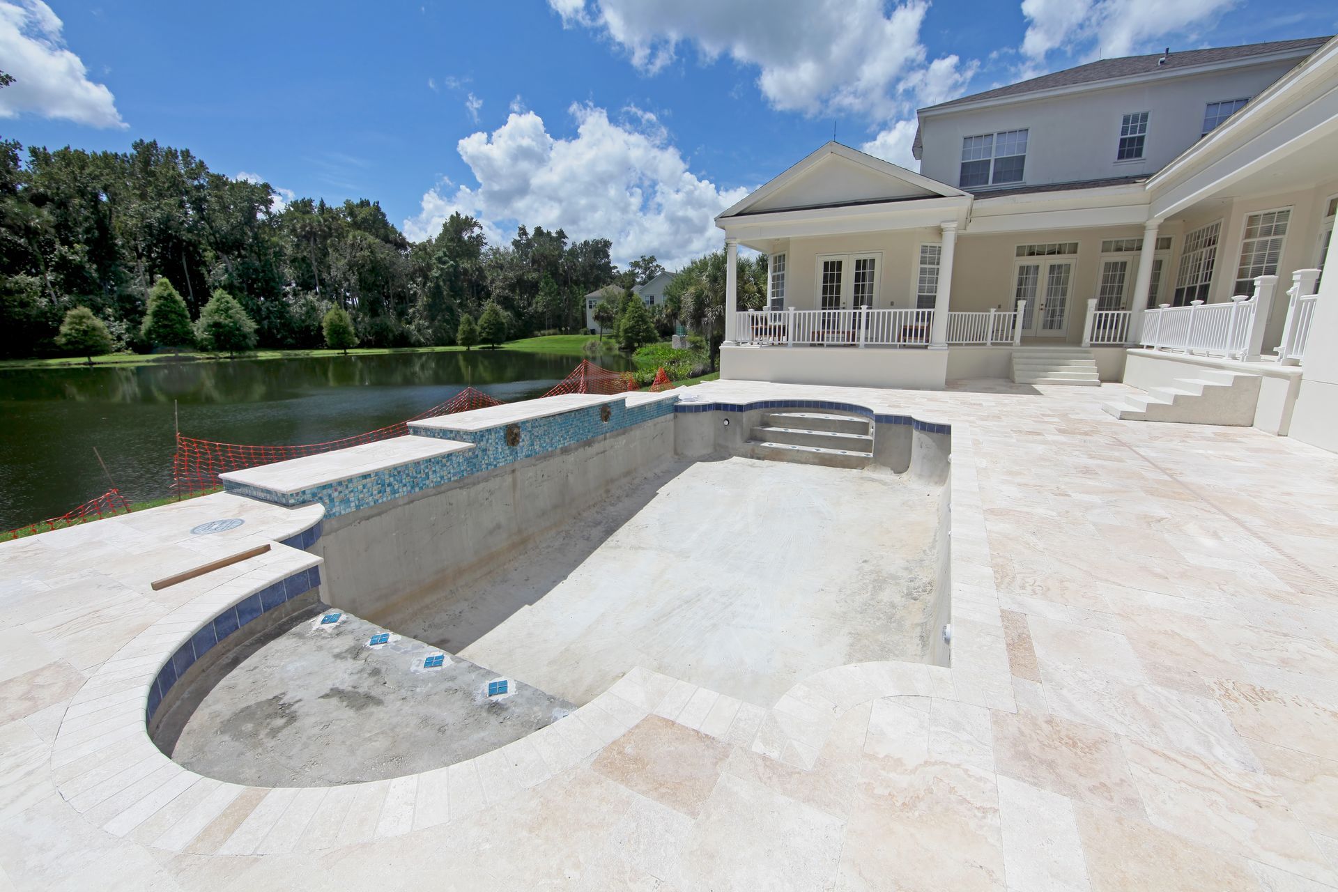 An Empty, Unfinished Swimming Pool With Light Stone Tiling — Sand & Stone in Robina, QLD