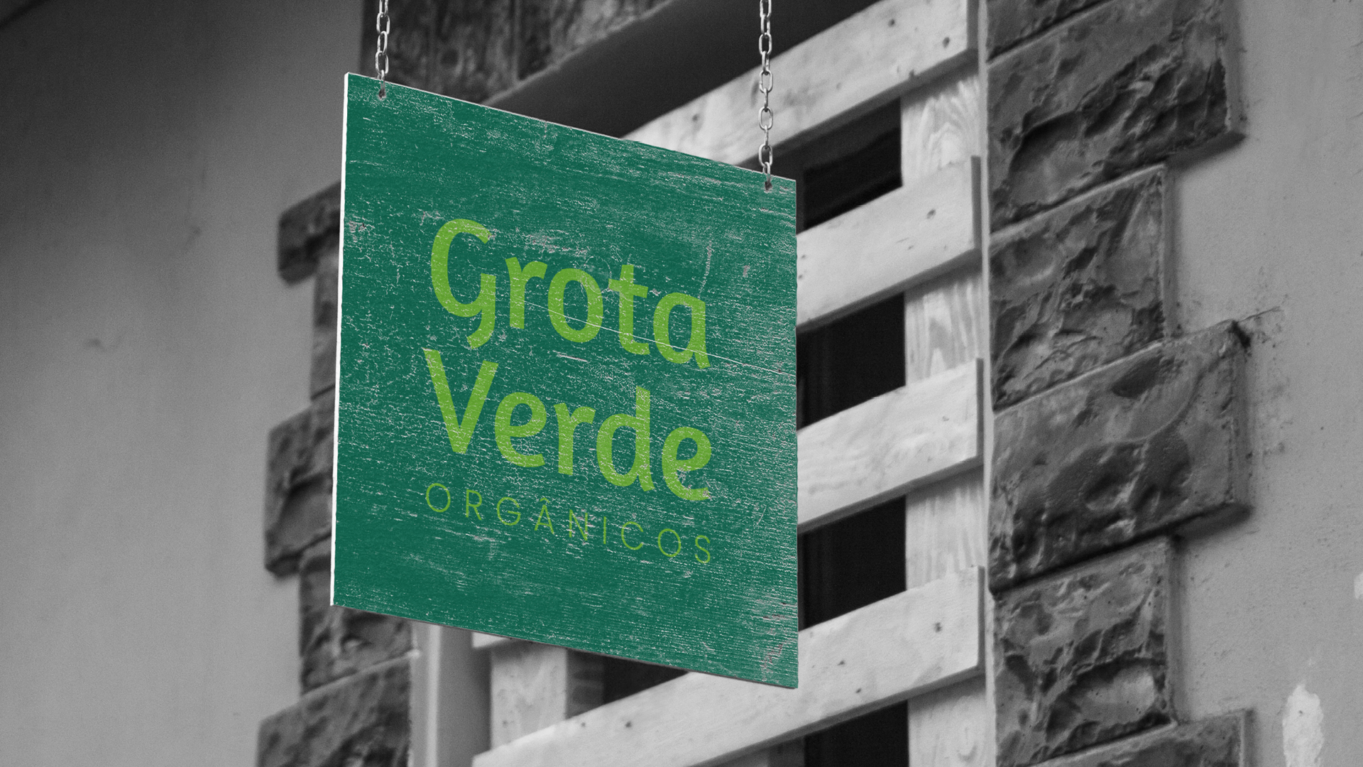 Uma placa verde que diz grotta verde está pendurada em uma parede de tijolos.
