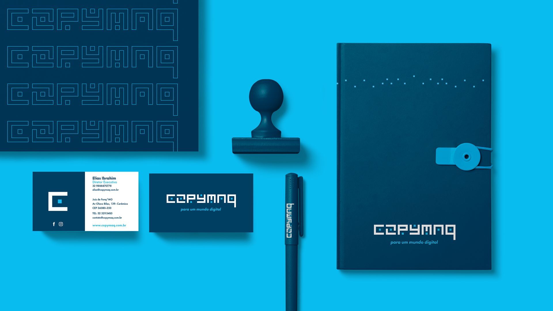 Conjunto de papelaria com logotipo em branco e azul. Inclui cartões de visita, carimbo, caneta e pasta.