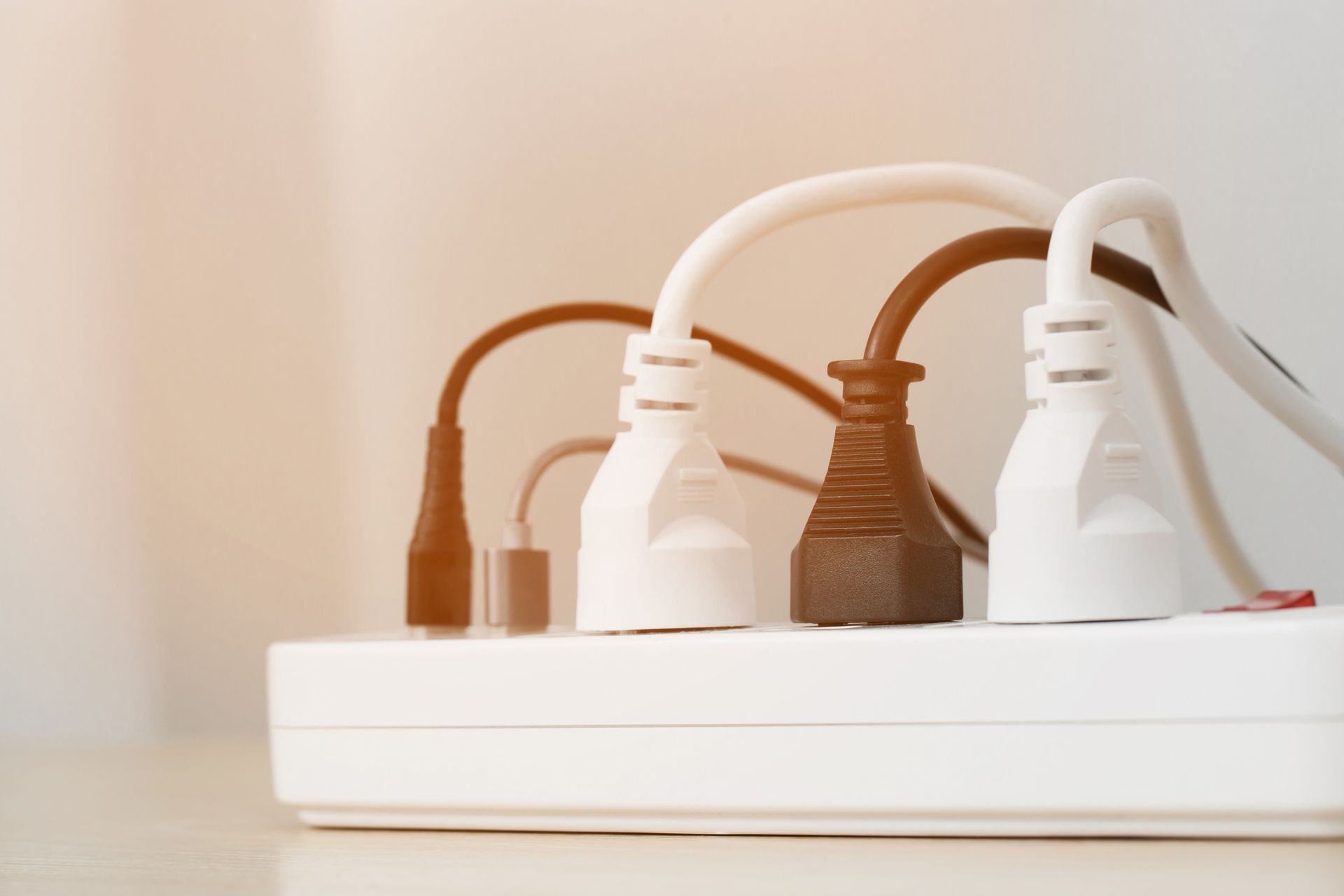 Power strip with multiple plugs inserted, various colors.