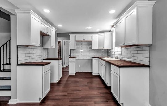 kitchen with white tiles and cabinets