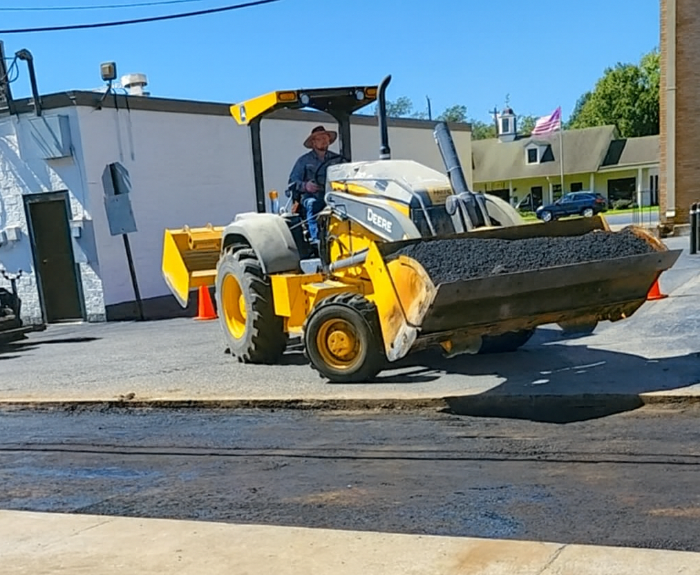 Operating a Yellow Asphalt Roller on A New Driveway — Sealy, TX — Sealy Paving, Inc.