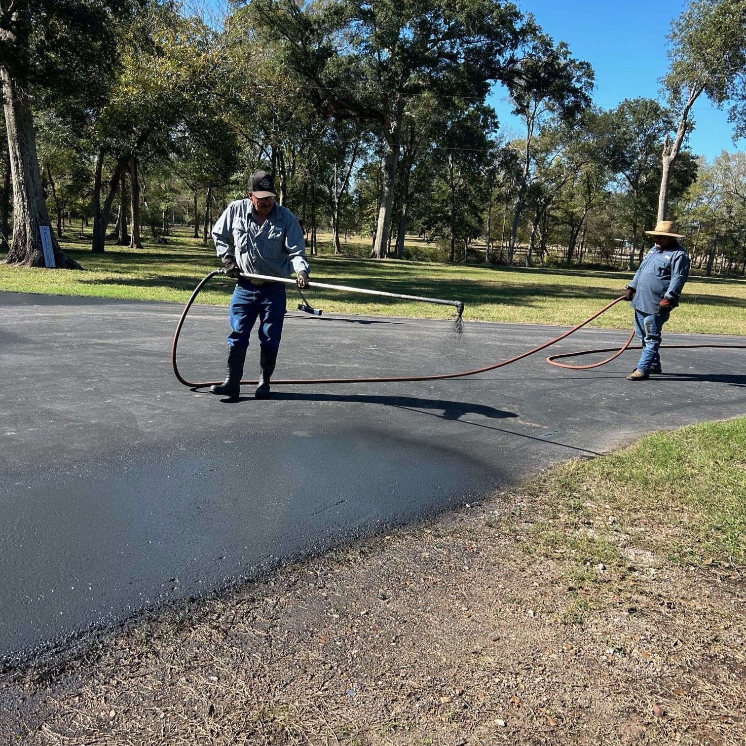 Filling a Crack in Asphalt with Hot Sealant — Sealy, TX — Sealy Paving, Inc. Filling a Crack in Asphalt with Hot Sealant — Sealy, TX — Sealy Paving, Inc.