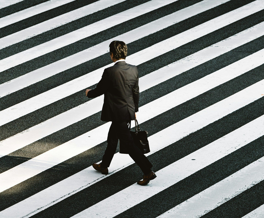 שני אנשים מסתכלים על מסך טלפון. אחד מצביע על המסך, שולחן עץ ושטיח ברקע.