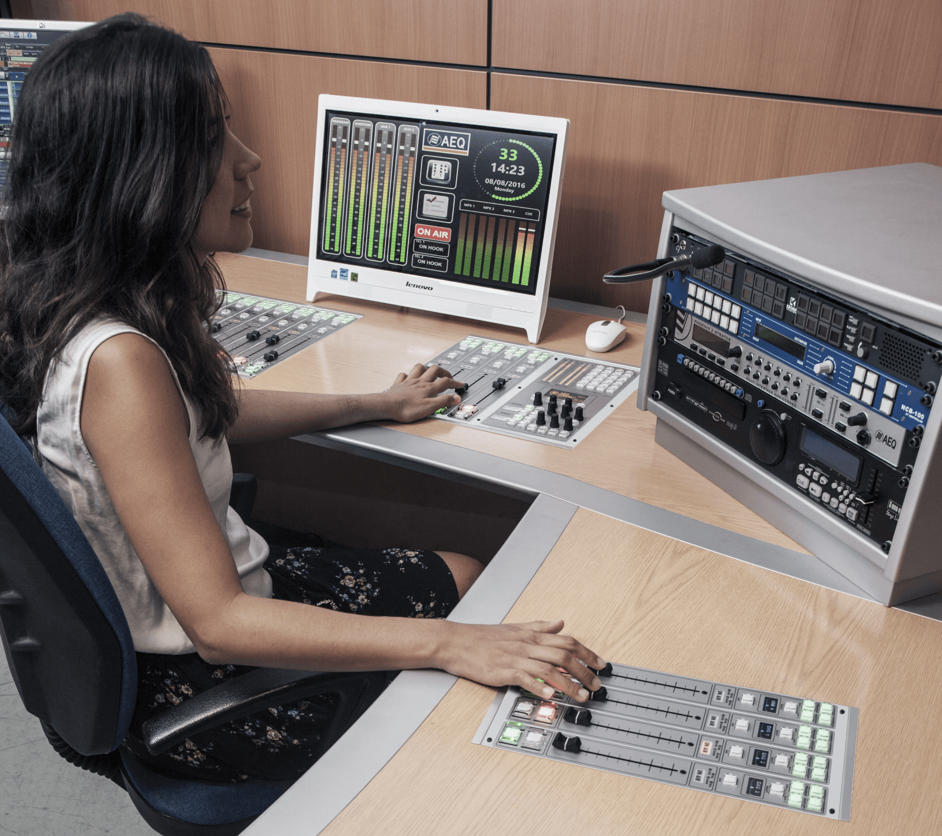 A woman is sitting at a desk with a monitor that says ' sonic ' on it