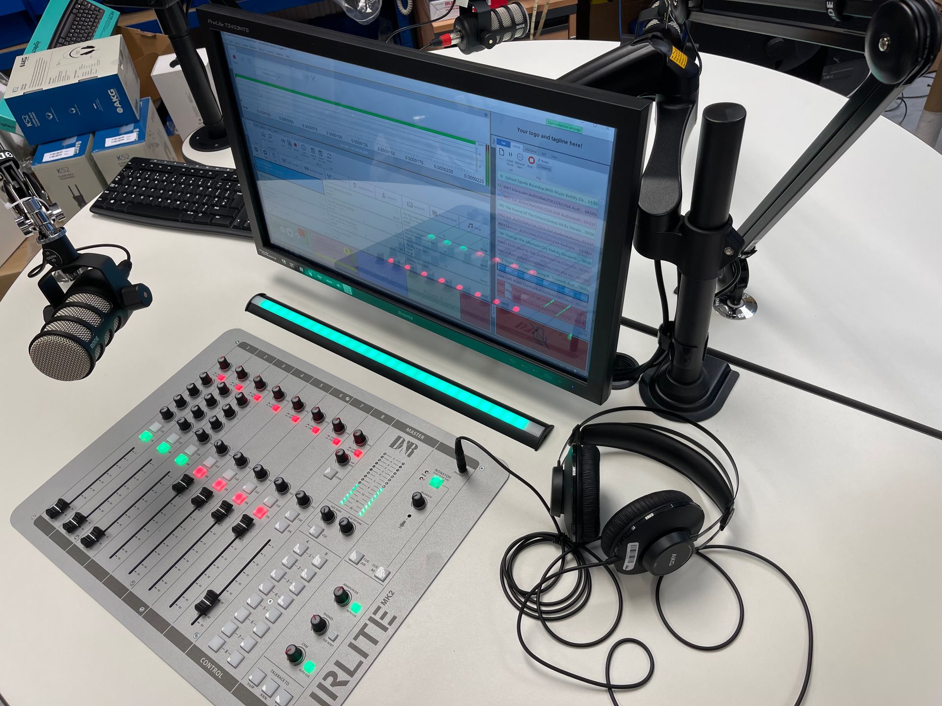 A desk with a monitor a mixer and headphones on it