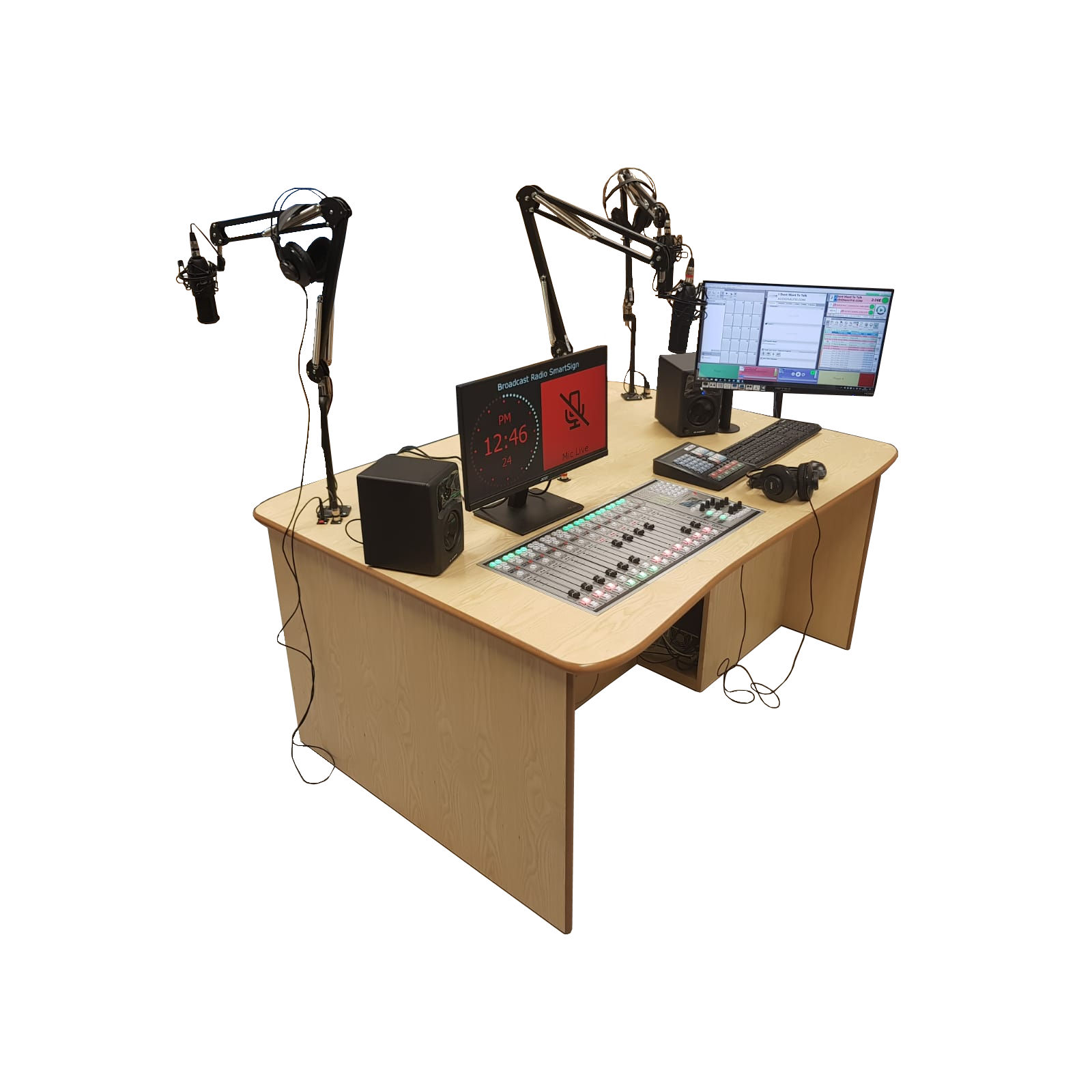 A wooden desk with a computer , microphone , monitor and mixer.