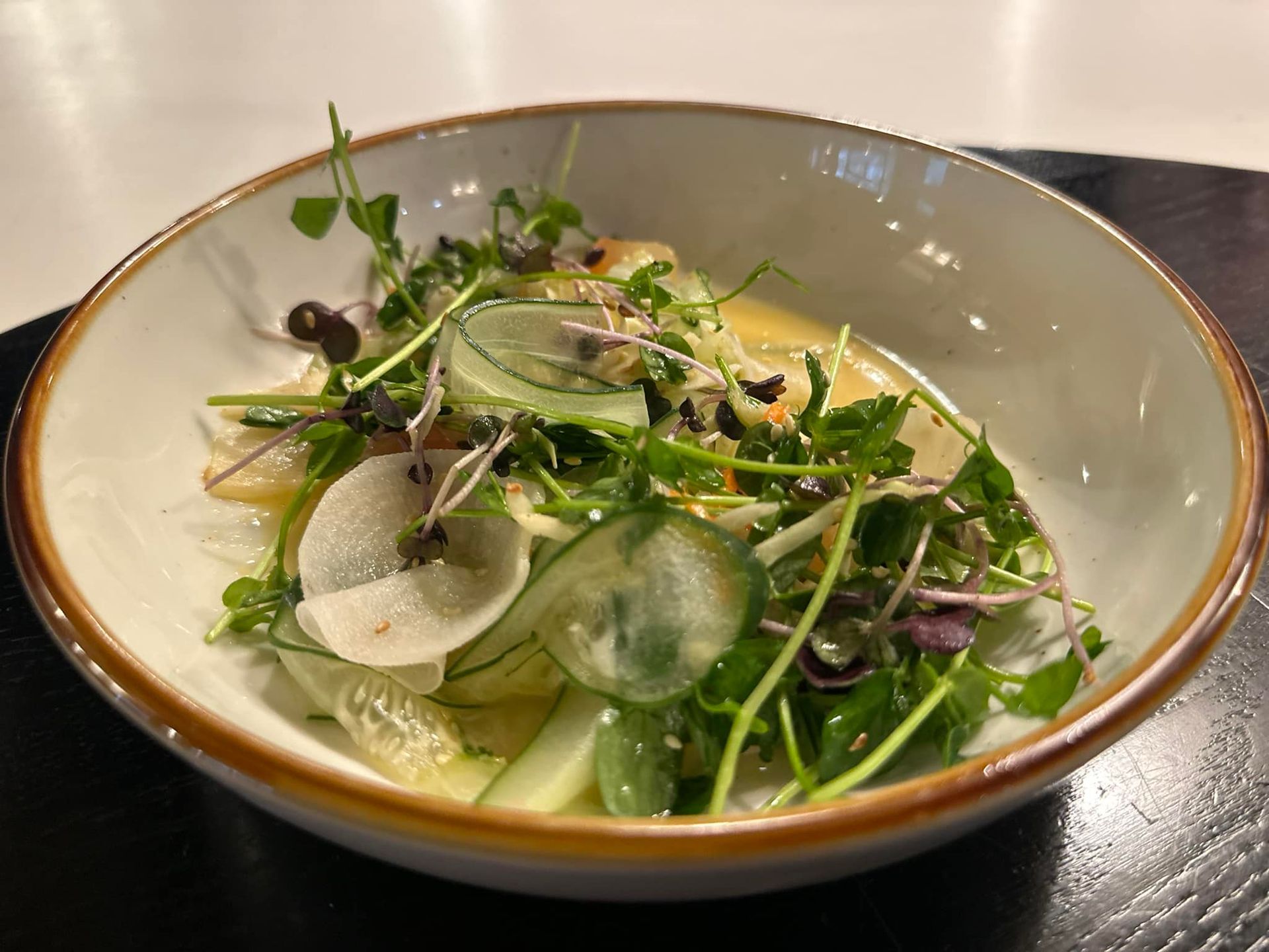 A close up of a bowl of salad on a table.