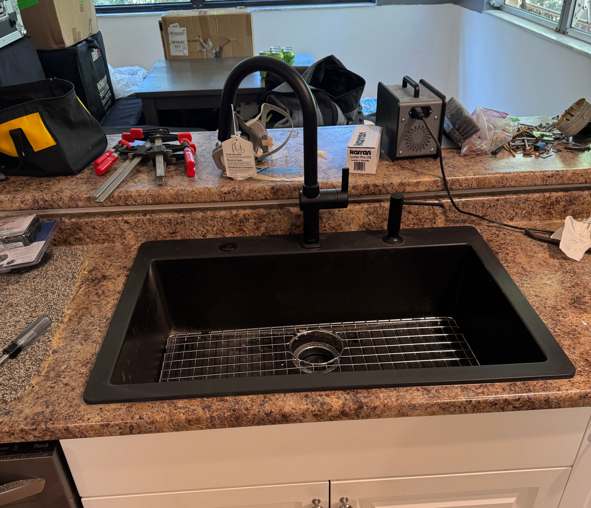 A person is fixing a sink pipe with a wrench.