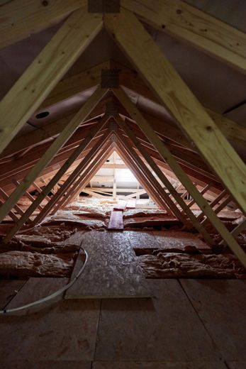 Looking up at the ceiling of an attic with wooden beams