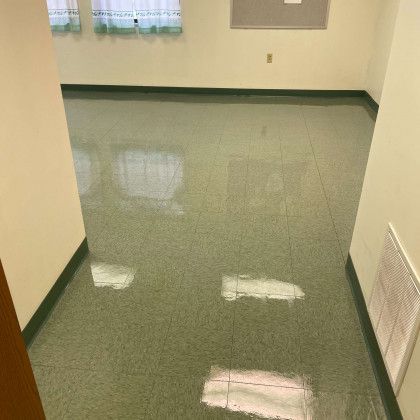 A room with a green tile floor and white walls.