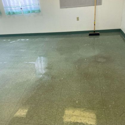 A room with a broom on the floor and a window.