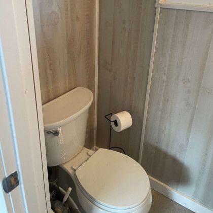 A bathroom with a toilet and a paper towel holder.