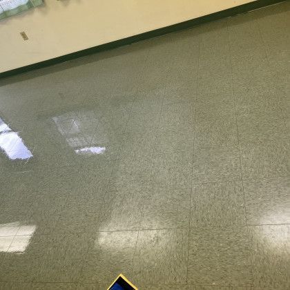 A tiled floor in a room with a tablet on it.