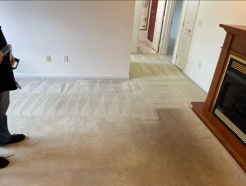 A man standing in a living room with a fireplace
