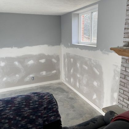 A living room with a couch , fireplace and window.