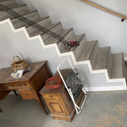A wooden staircase with a wooden desk and a chair underneath it.