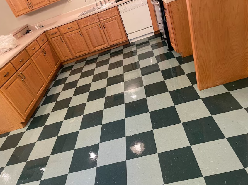 A kitchen with a checkered floor and wooden cabinets