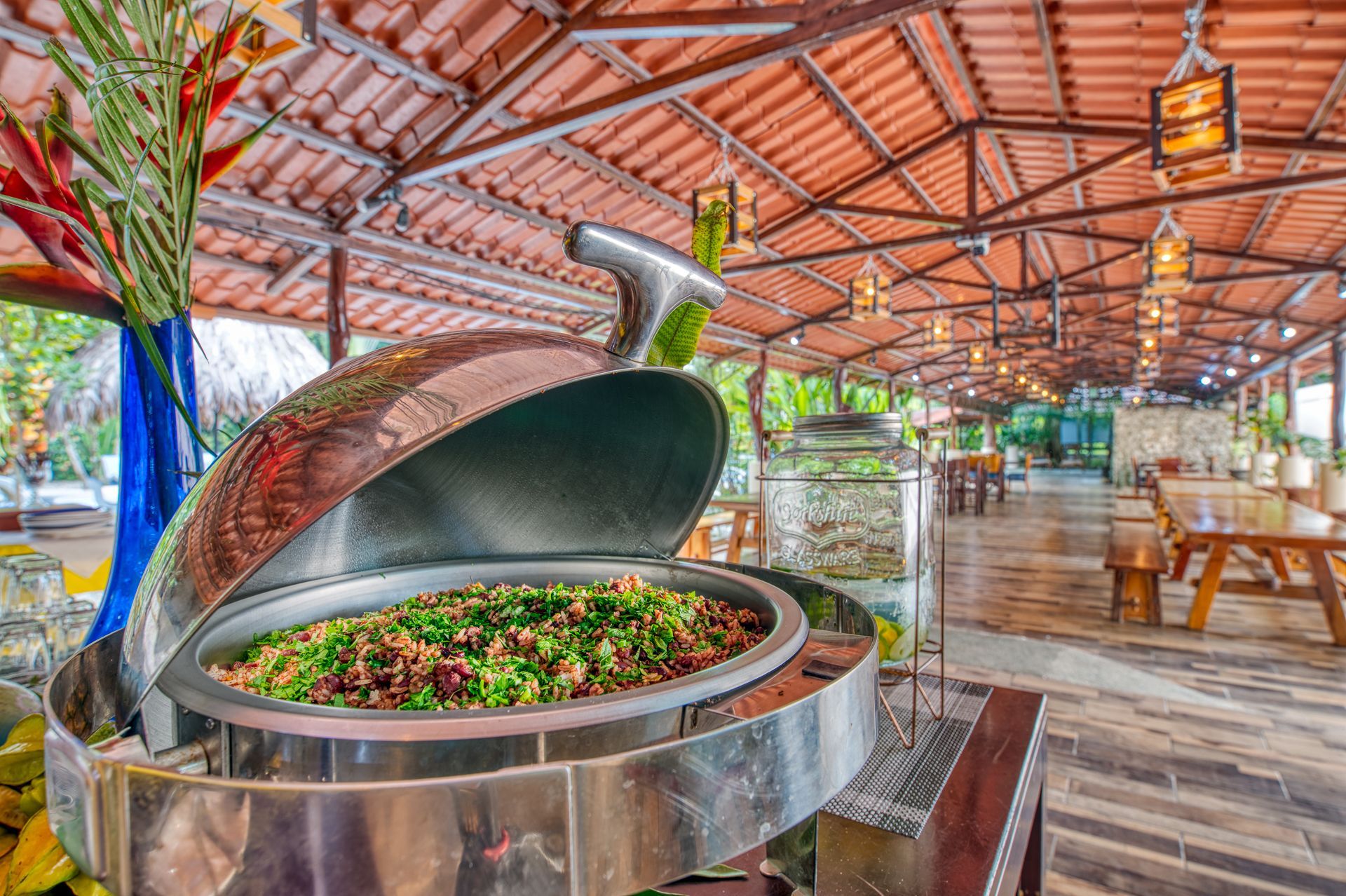 A buffet filled with food is sitting under a roof in a restaurant.