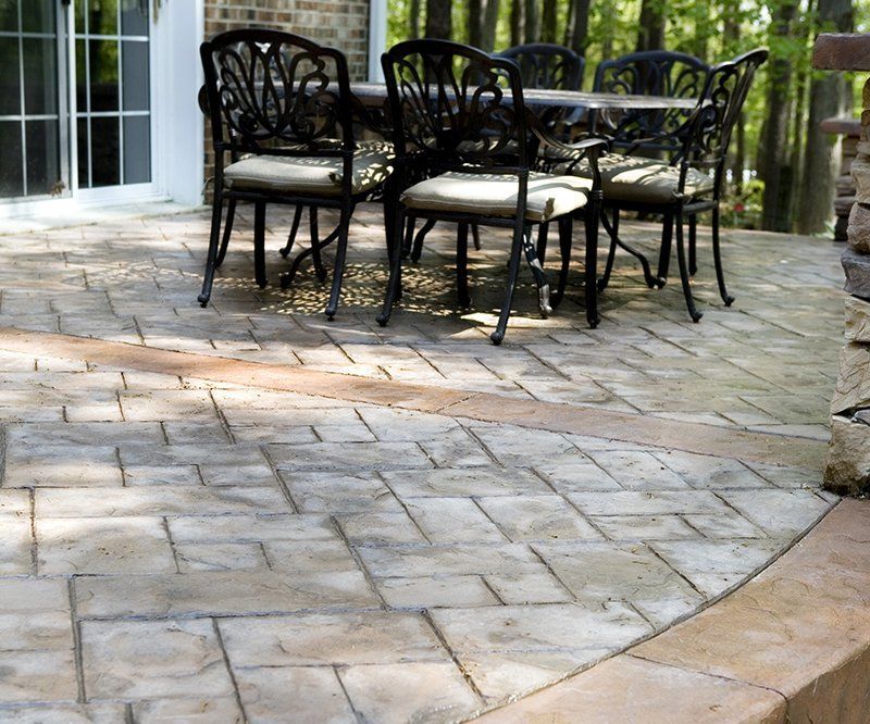 A patio with a steel table and chairs on it