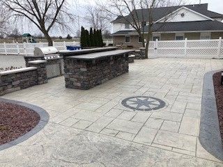 A patio with a grill and a bar in front of a house