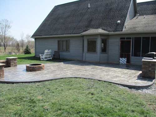 There is a fire pit in the backyard of a house