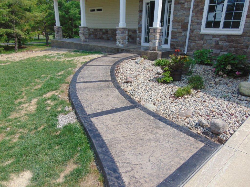A curved concrete walkway leading to the front of a house