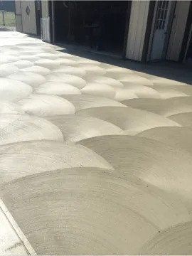 A close-up of a textured concrete driveway in front of a garage