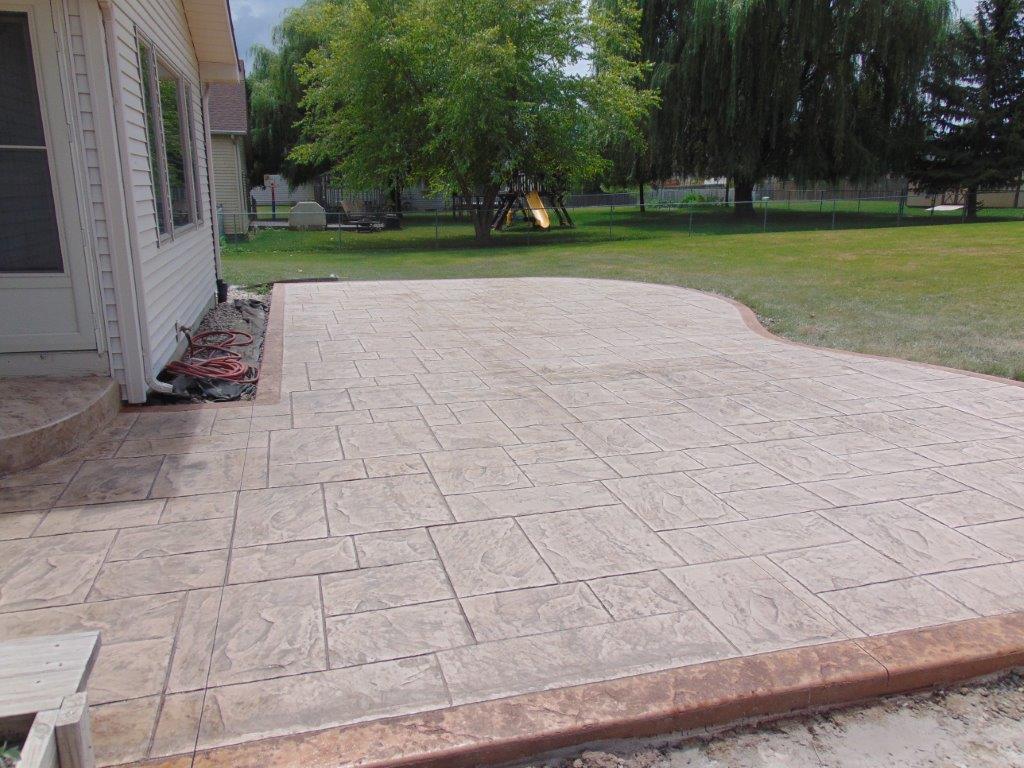 A concrete driveway is being built in front of a house