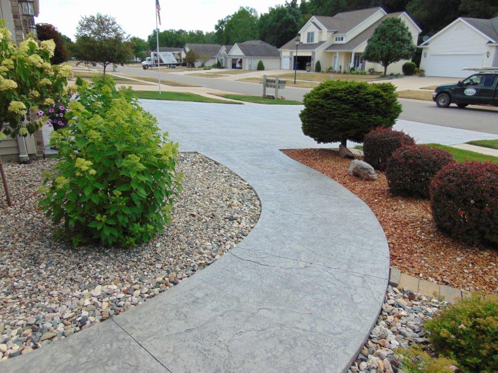 A driveway with a truck parked on the side of it