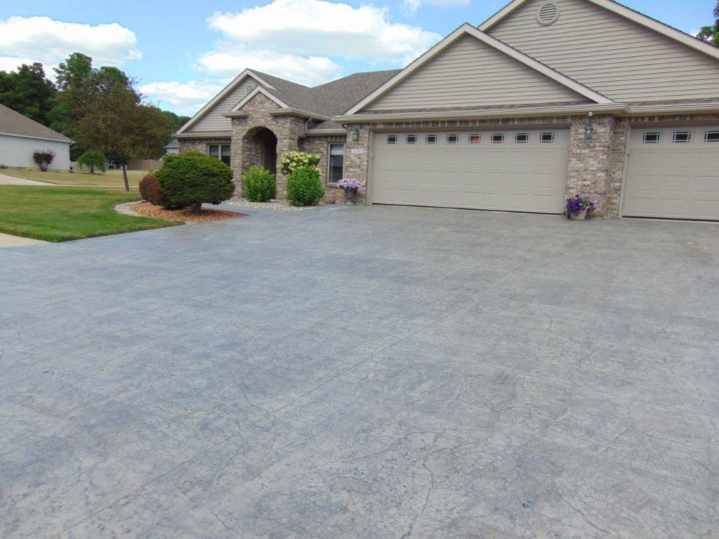 A large house with a concrete driveway in front of it