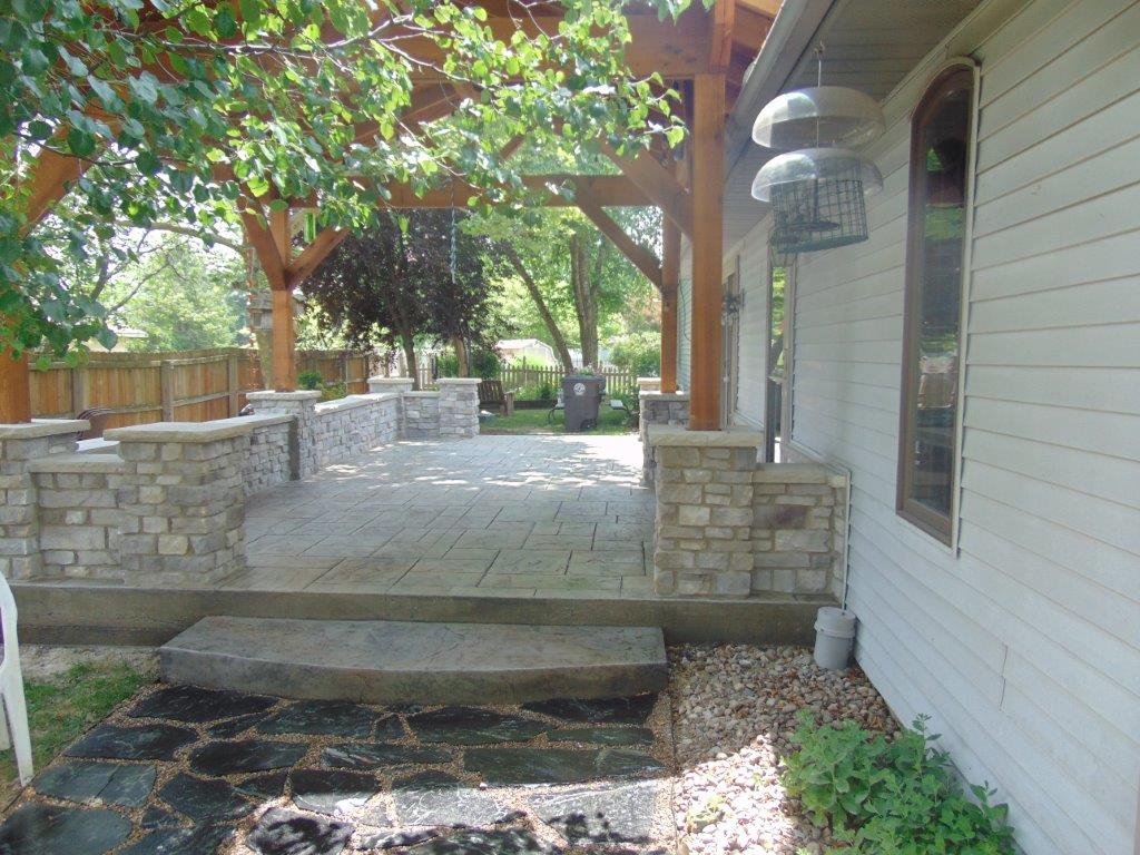 A white house with a patio and trees in front of it