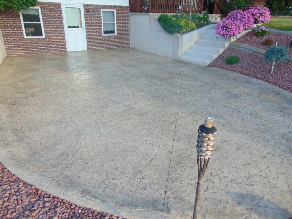 A concrete driveway with a torch in front of a house