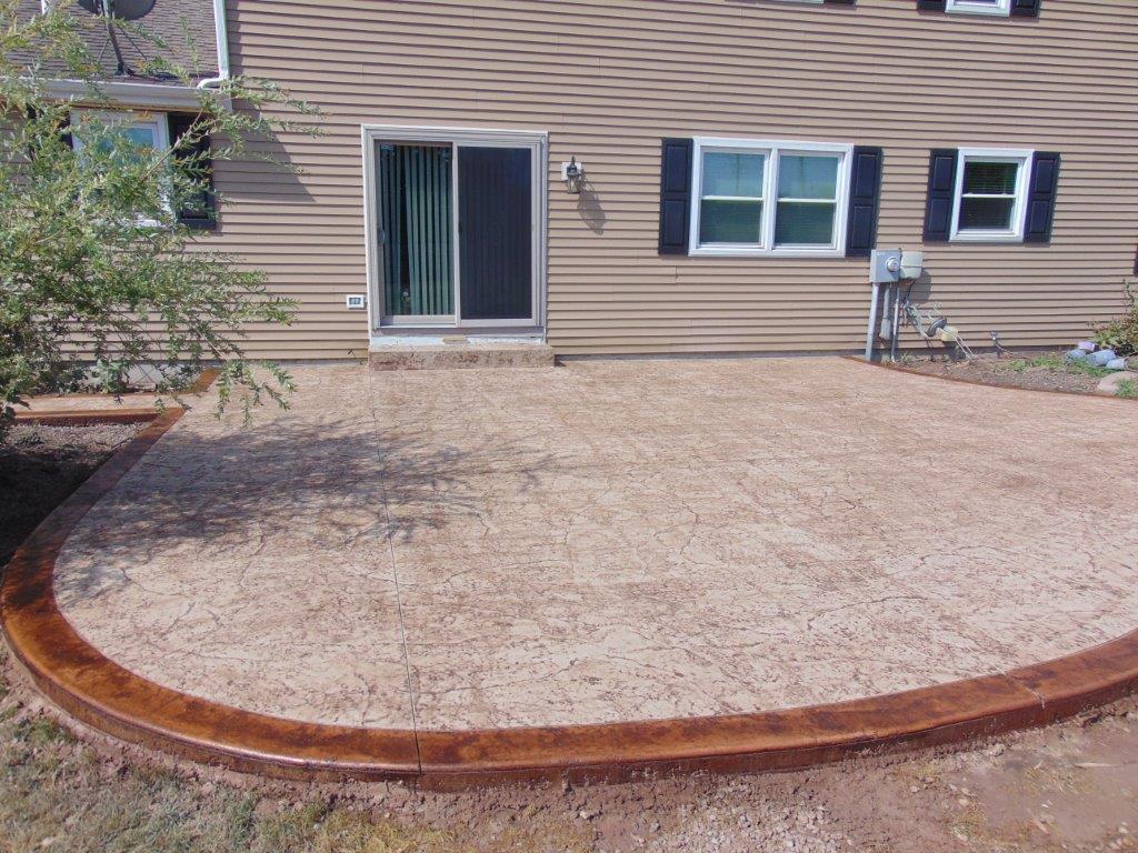 A beautiful house with a concrete patio in front of it