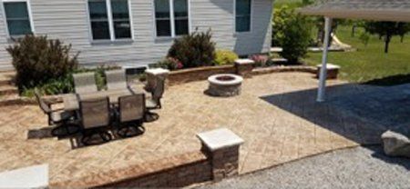 An aerial view of a patio with a table and chairs, and a fire pit