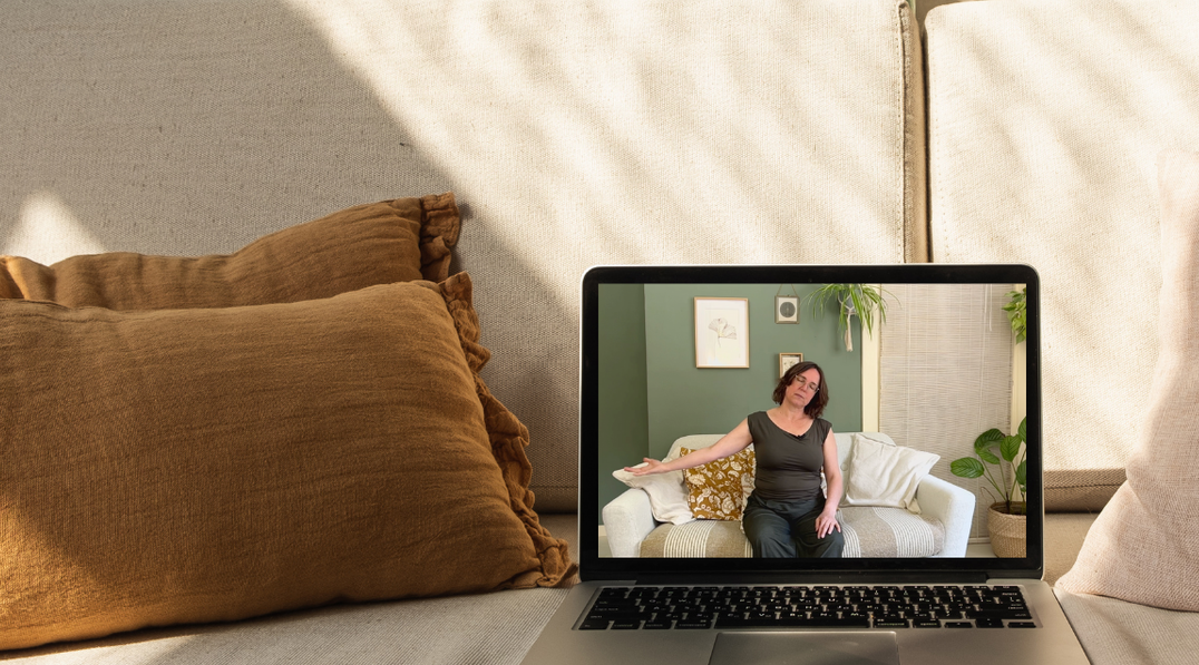 Een vrouw bekijkt op een laptop een yogavideo van De Online Yogaschool