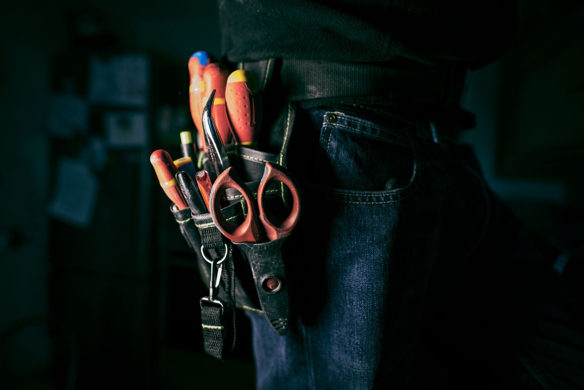 A person is wearing a tool belt with tools in it.
