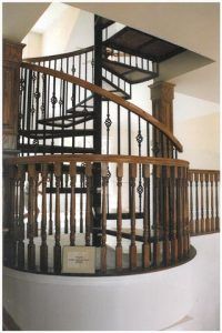A spiral staircase with a wooden railing in a house