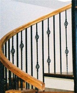 A spiral staircase with a wrought iron railing and a wooden handrail