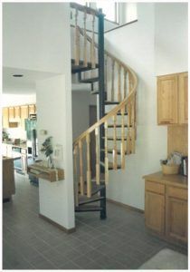 A kitchen with a spiral staircase leading up to the second floor