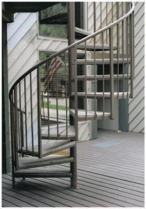 A spiral staircase with a metal railing on a deck