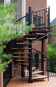 A spiral staircase is outside of a brick building