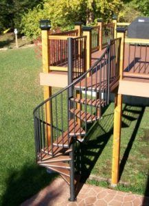 A wooden deck with a spiral staircase leading up to it