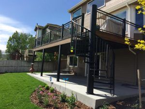 There is a spiral staircase leading up to the deck of a house.