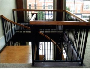 A staircase with a wooden railing and a metal railing