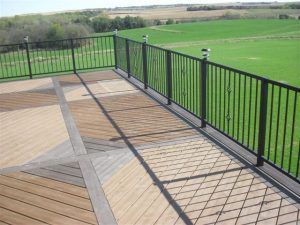 A balcony with a fence and a view of a field.