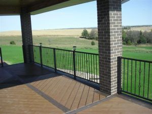 A balcony with a railing and a view of a golf course.