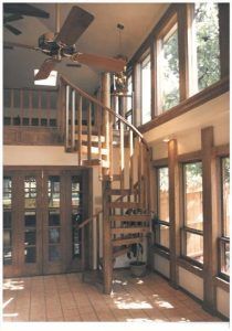 A room with a spiral staircase and a ceiling fan