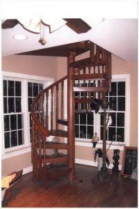 A living room with a spiral staircase and a ceiling fan
